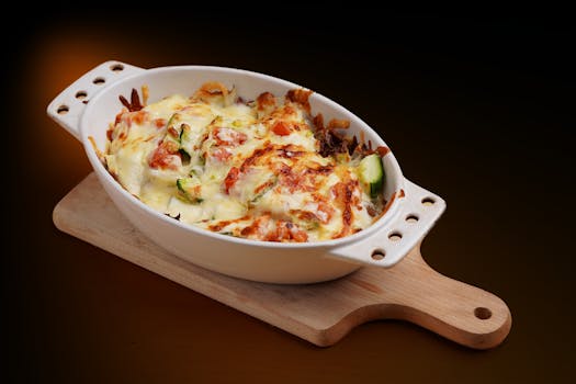 Gratin de légumes au fromage doré, servi dans un plat en céramique sur une planche en bois.